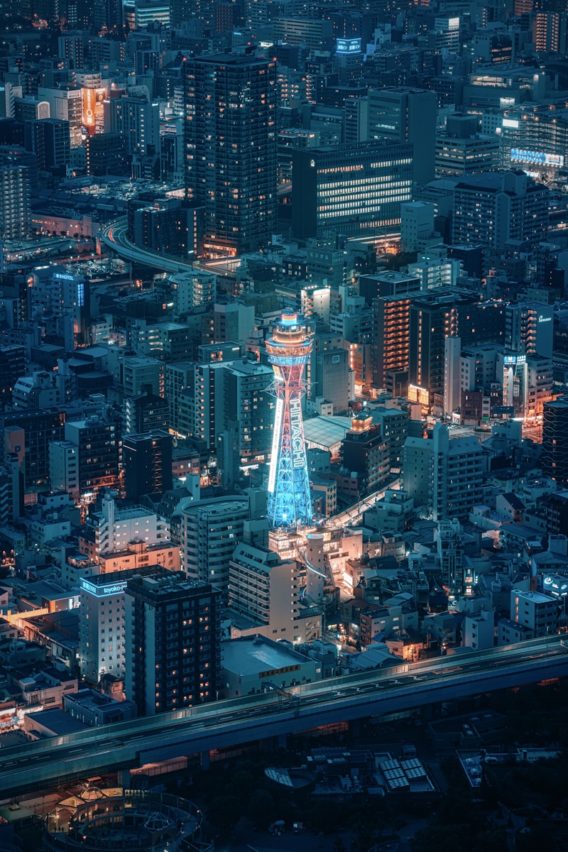 City lights illuminate skyscrapers at night.